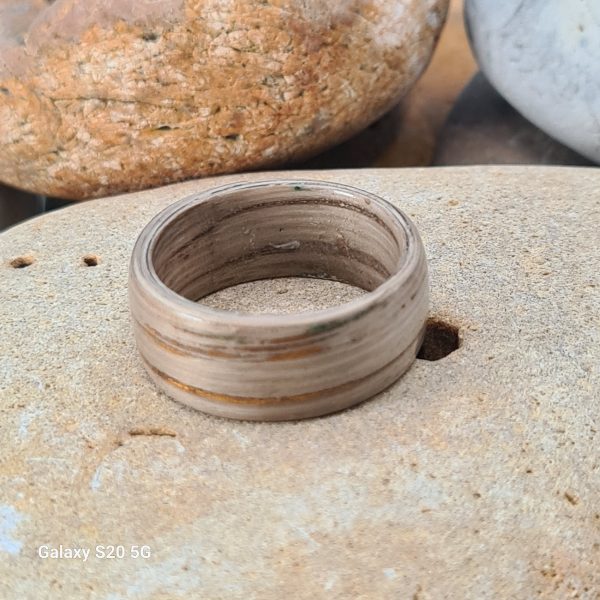 Oak bentwood ring laying flat on a beach stone.